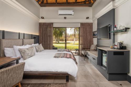 a bedroom with a large bed and a table at Mokuti Etosha in Namutoni
