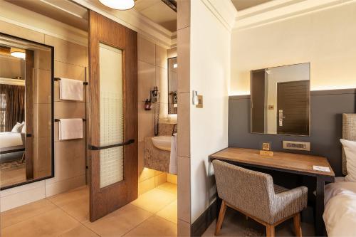 a hotel room with a desk and a bathroom at Mokuti Etosha in Namutoni