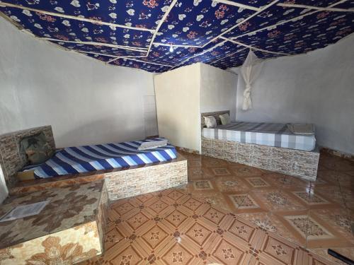 a room with two beds and a blue ceiling at Finfoot Lodge in Lamin Koto