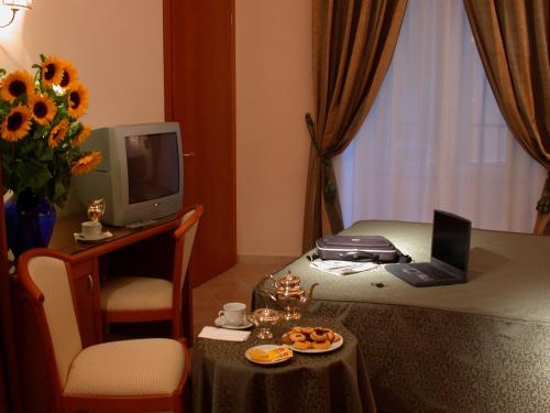 una camera d'albergo con letto e tavolo con computer portatile di Hotel Philia a Roma