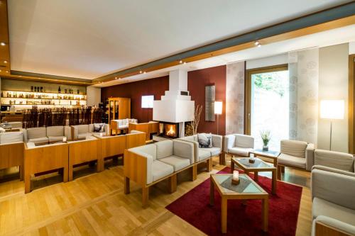 a living room with couches and a bar at Ringhotel Schorfheide I Waldresort Werbellinsee in Joachimsthal