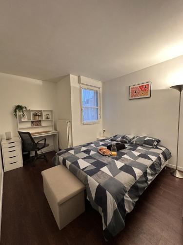 a bedroom with a black and white bed and a desk at T2 Evry Centre - Proche de Orly et Paris in Courcouronnes