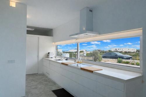 a kitchen with a large window with a view at Villa Codolar in Cala Morell