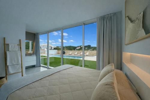 a bedroom with a large bed and a large window at Villa Codolar in Cala Morell
