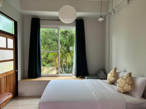 a bedroom with a bed and a large window at T terrest Residence in Thai Muang