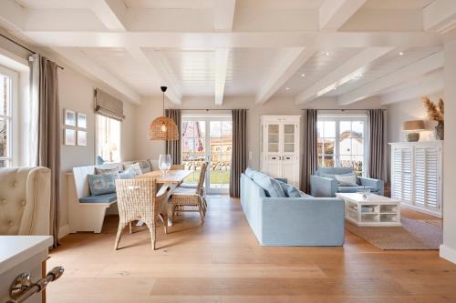 a living room with blue furniture and a table at Wiesen Engel in Oldsum
