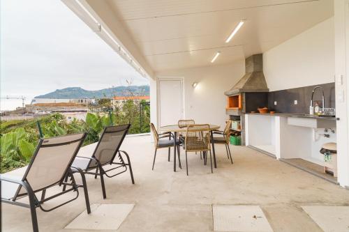 a kitchen and dining room with a table and chairs at GuestReady - Funchal Hideaway with BBQ in Funchal