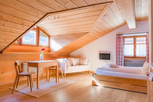 a bedroom with a bed and a table in a room at Landhaus Alger in Immenstadt im Allgäu
