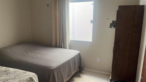 a small bedroom with a bed and a window at Casa Temporada Peter in Tutóia