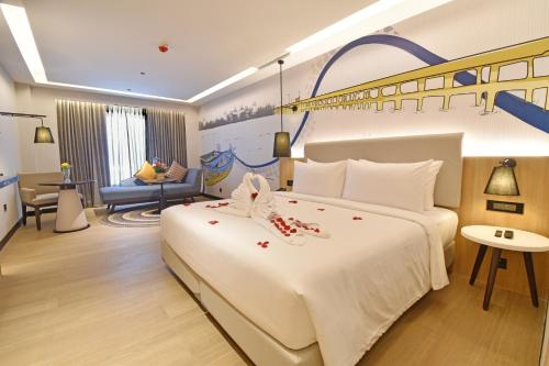 a bedroom with a large white bed with decorations on it at Sands Point Hotel in Pondicherry