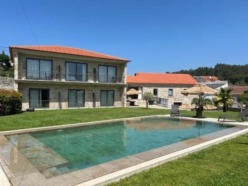 a large swimming pool in front of a house at Paços do Douro, Chambre privée avec piscine in Romariz