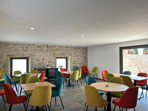 a dining room with tables and colorful chairs at Paços do Douro, Chambre privée avec piscine in Romariz