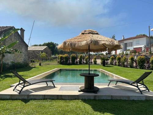 a table and two chairs under an umbrella next to a pool at Paços do Douro, Chambre privée avec piscine in Romariz