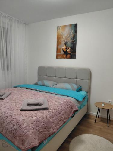 a bedroom with a bed with a painting on the wall at High Above 6 in Vranješ