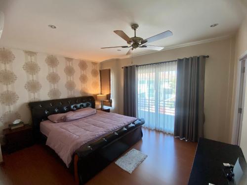 a bedroom with a bed and a ceiling fan at J&Y Happy Home in Ban Rong