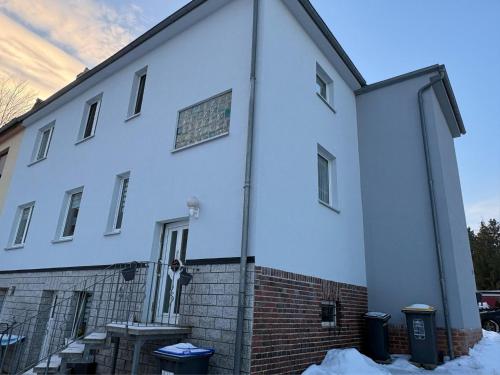 a large white building with snow on the ground at Gabis Ferienwohnung Zwickau in Zwickau