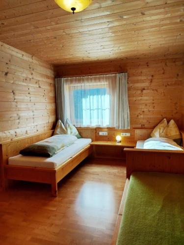 a bedroom with two beds in a wooden cabin at Ebner Casa in Heiligenblut