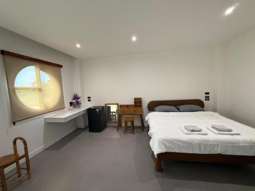 a bedroom with a bed and a window and a table at S77 Good View in Roi Et