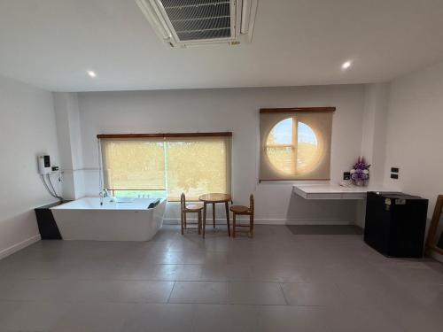 a bathroom with a tub and a table and a sink at S77 Good View in Roi Et