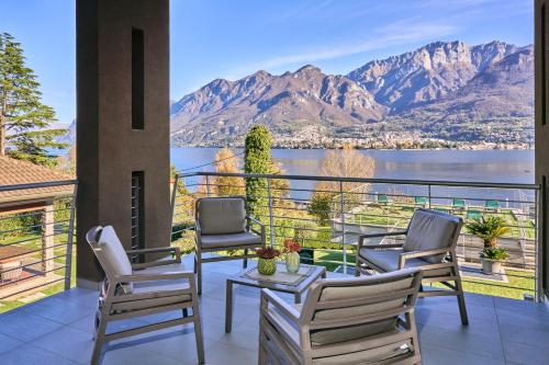 a balcony with chairs and a table and a view of a mountain at Bellagio Village - Holiday Apartments by the Lake - Seasonal Warm Pool and Sauna in Oliveto Lario