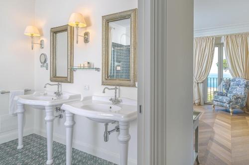 a bathroom with two sinks and a mirror at La Tuja Relais du Parc in Vico Equense