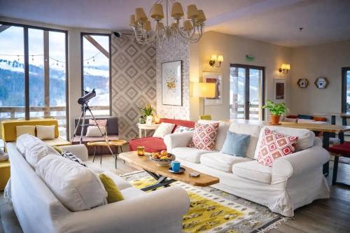 a living room with white couches and a table at Akasha Retreat in Bran