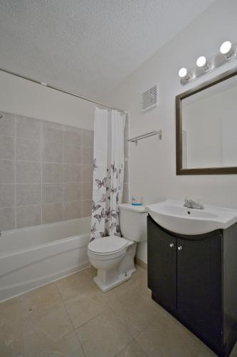 a bathroom with a white toilet and a sink at MXP Special Rooms in Saskatoon