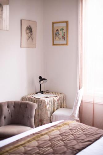 a bedroom with a bed and a table and a chair at Villa MONIKA in Dieppe