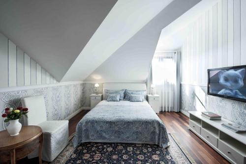 a bedroom with a bed and a tv on a wall at Villa Victoria in Rydzewo