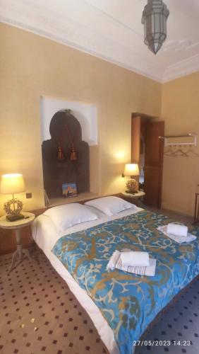 a large bed in a room with two tables and two lamps at Riad Fadela in El Jadida