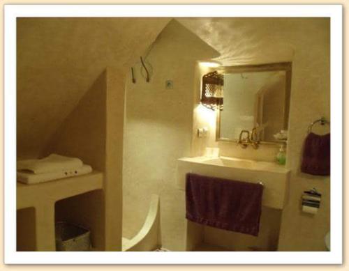 a bathroom with a sink and a mirror at Riad Fadela in El Jadida