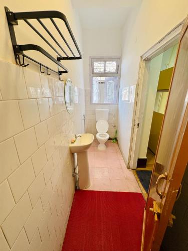 a bathroom with a toilet and a sink at Yaro Backpackers Hostel in Guwahati