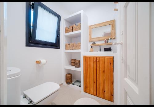 a bathroom with a toilet and a wooden door at La Finca Blanca Javea in El Tosalet