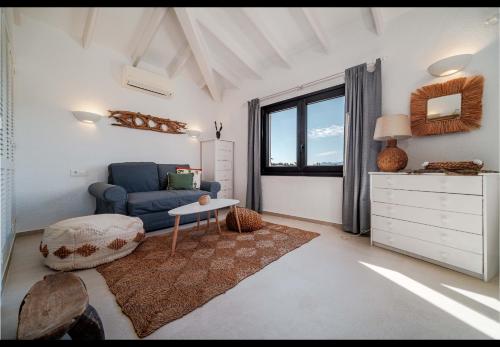 a living room with a blue couch and a table at La Finca Blanca Javea in El Tosalet