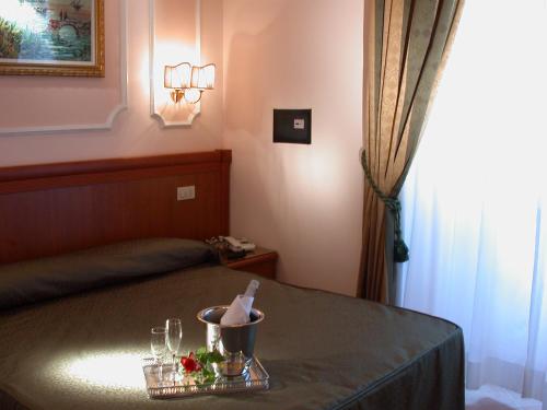 um quarto de hotel com uma cama com uma mesa com flores em Hotel Philia em Roma