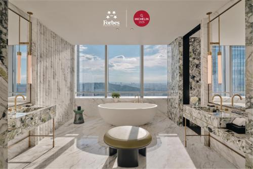 a bathroom with a tub and two sinks at Park Hyatt Changsha in Changsha