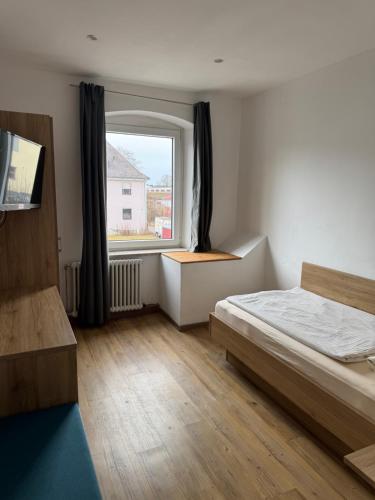 a bedroom with a bed and a large window at Gasthaus - Hotel Neue Post in Meitingen