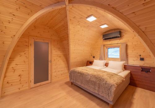 a bedroom with a bed in a wooden room at Snow Resort Kirkenes in Kirkenes