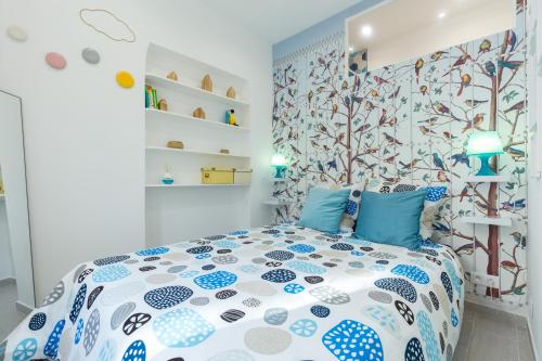- une chambre avec un lit doté d'oreillers bleus et une fresque murale dans les arbres dans l'établissement La Casa Madere- Centre ville prés gare - wifi -confort et cosy prés des transports en communs, à Nice