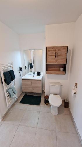 a white bathroom with a toilet and a sink at Studio avec parking privé - Proche écoles & hôpital - Valence in Valence