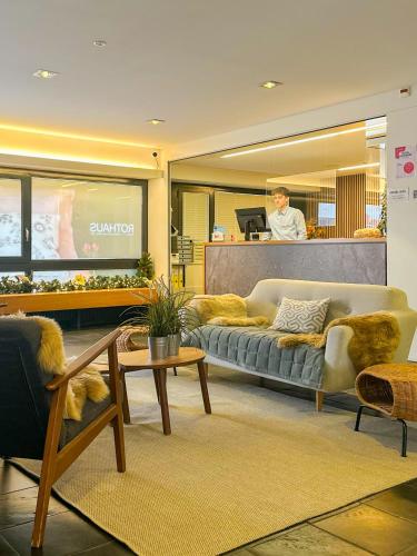a living room with a couch and a man in the background at Hotel Rothaus Luzern & Peruvian Culinary Art in Lucerne