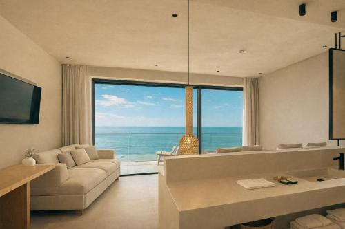 a living room with a couch and a large window at Zeus Eleva Miraya in Agios Nikolaos