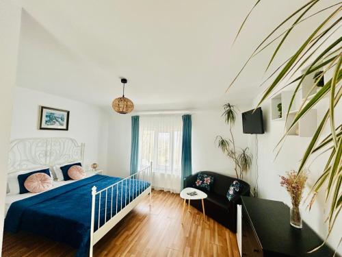a bedroom with a blue bed and a couch at LakeViewHouse in Năvodari