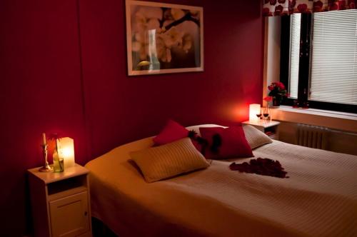 a red bedroom with a large bed with red walls at Hotel Tunneli in Sastamala