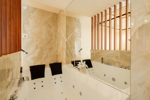 a white bathroom with a tub and a window at Bed Cinecittadue in Rome