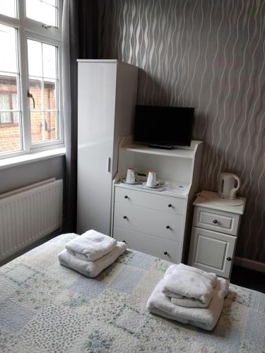 a bedroom with a bed and a dresser with two towels at The Chase Inn in Bishops Frome