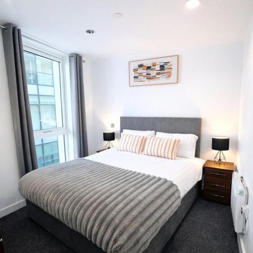 a bedroom with a large bed and a window at Apartment in MediaCity in Manchester