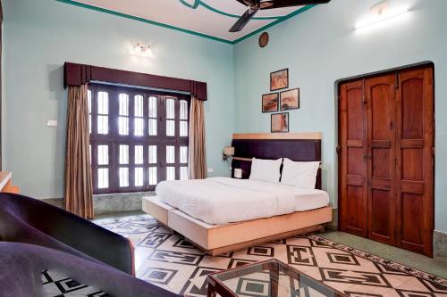 a bedroom with a bed and a large window at Palette by CheckIn Heritage Scindia Ghat in Varanasi