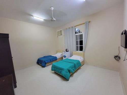 a hospital room with two beds and a window at Room Quriyat in Ramlah
