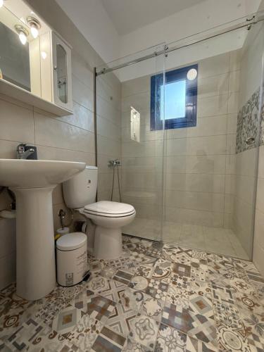 a bathroom with a sink and a toilet and a shower at Marina Helios Home in Áyios Yeóryios